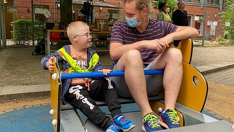 Bild von Kind und Erwachsenem auf dem Spielplatz