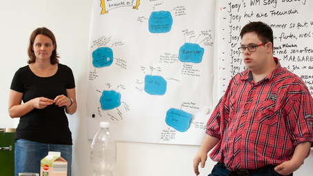 Frau und Mann vor einem Flipchart